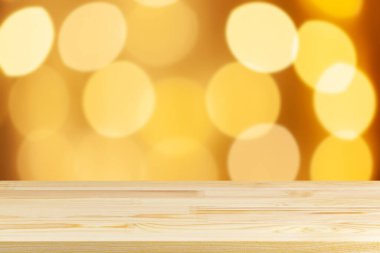 Ahşap masa üstü bulanık sarı noel ağacı ışıkları arka plan