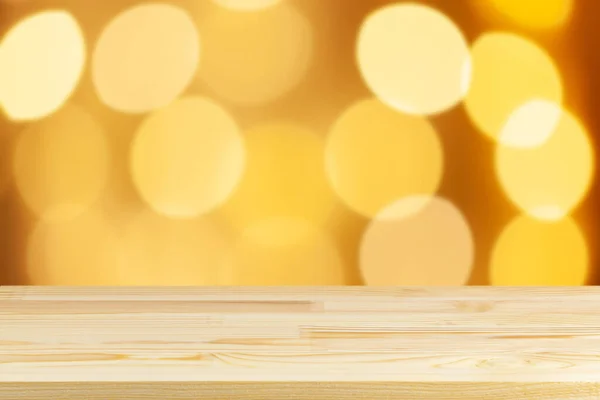 Ahşap masa üstü bulanık sarı noel ağacı ışıkları arka plan