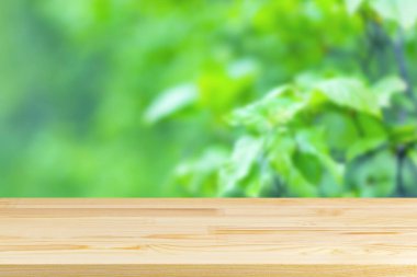 Bulanık yeşil çalılıklarda ahşap masa üstü