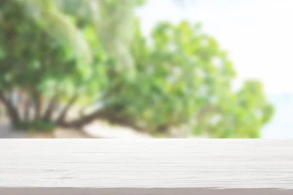 Bulanık yeşil ahşap arka planda beyaz tahta masa