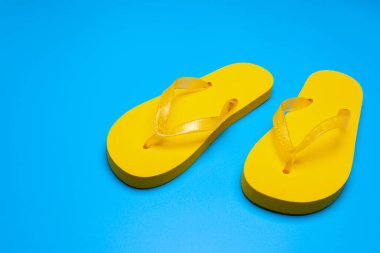 Mavi arka planda sarı parmak arası terlikler
