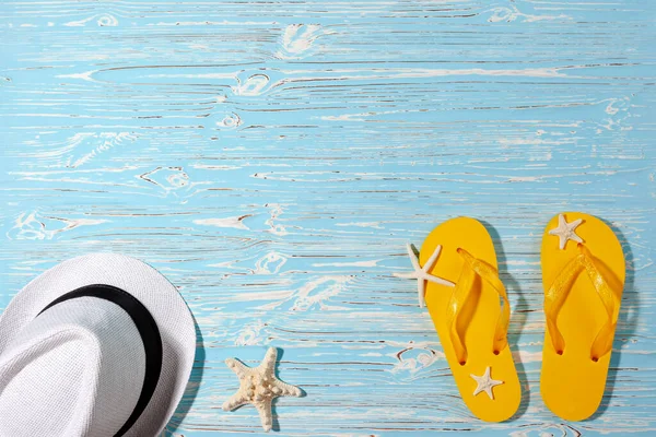 黄色橡胶翻盖，白色海滩帽，蓝木背景上的海星 — 图库照片