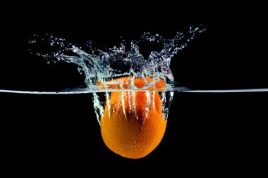 Bir yeşil elma beyaz bir zeminde suya düşüyor. Damlalar, damlalar ve kabarcıklar var.