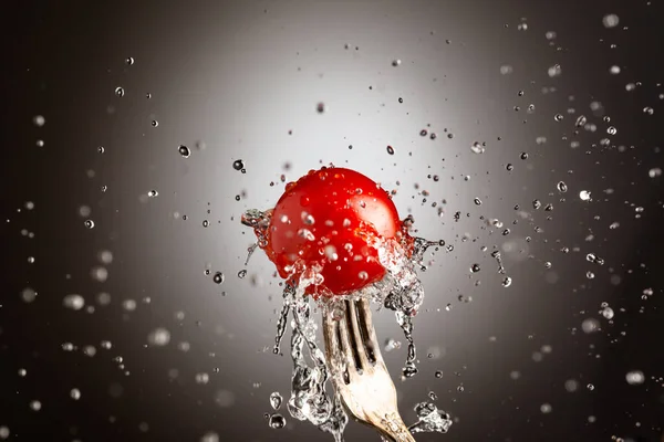 成熟的樱桃西红柿，在叉子上的水花里 — 图库照片