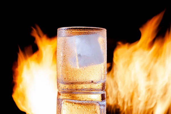 Egy pohár vodka egy fekete háttér a tűz — Stock Fotó