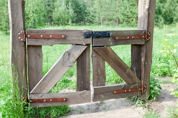 Porte chiuse in legno al prato, il passaggio è chiuso — Foto Stock