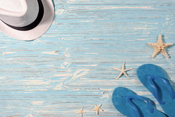 帽子和海滩在蓝色的木制背景上翻滚。海星从上面看 — 图库照片