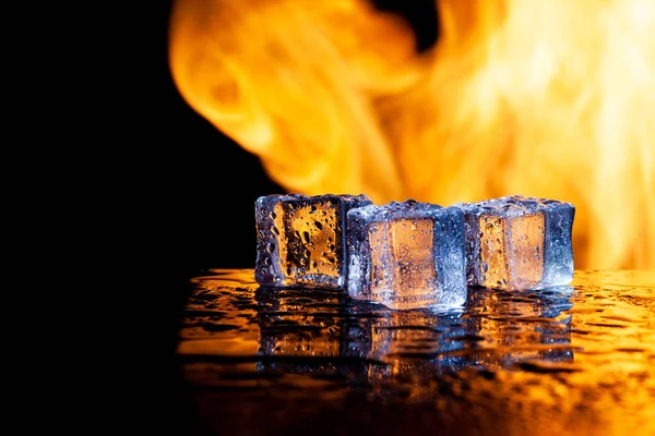 黒の背景に氷の三つの立方体と炎 — ストック写真