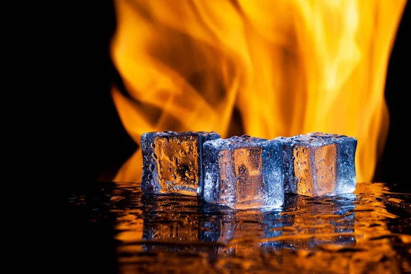 Ateşin, ateşin ve buzun arka planına dayanan üç buz küpü, metnin altına yerleştirilsin