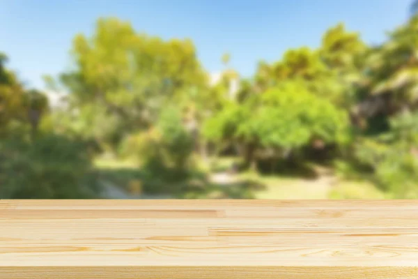 wood table top on blur trees and sky background