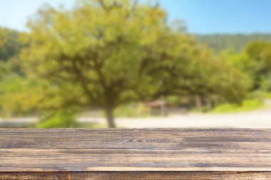 Ahşap masa üstü bulanık yeşil ağaç ve mavi gökyüzü arkaplanı