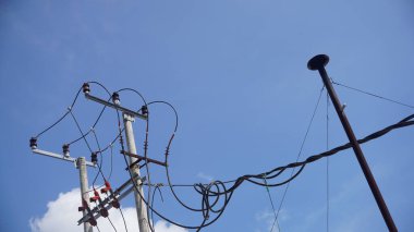 Mavi arkaplanlı yüksek voltaj direği.