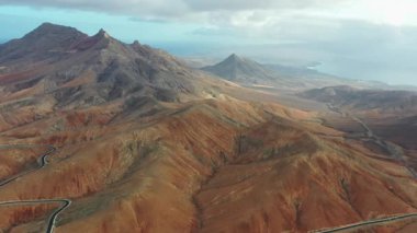 Fuerteventura, Kanarya Adaları 'ndaki Sicasumbre dağ yolunun kurak volkanik arazi ve dramatik doğal manzaralarla çevrili sinematik görüntüsü..
