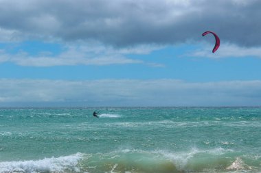 Uçurtmacıların Fuerteventura 'daki Sotavento Sahili' nin turkuaz sularında süzülerek bu popüler su sporunun heyecanını ve enerjisini yakaladıkları canlı bir sahne..