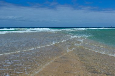Sotavento 'nun dar kumsalında iki dalga çarpışıyor ve büyüleyici bir köpük ve yansıma deseni oluşturuyor. Fotoğraf, bölgenin eşsiz coğrafyasını, hareketini ve dinginliğini aktarıyor..
