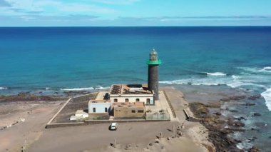Punta de Jandia Deniz Feneri 'nin Kanarya Adaları' ndaki Fuerteventura 'nın en güney noktasındaki çarpıcı hava aracı görüntüsü. Video engebeli volkanik kıyı şeridini vurguluyor..