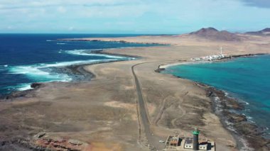 Fuerteventura 'nın güney ucundaki Punta de Jandia Deniz Feneri' nin engebeli kıyı şeridi ve temiz Atlantik sularıyla çevrili çarpıcı hava görüntüleri..