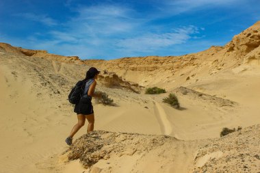 Bir kadın yürüyüşçü Fuerteventura 'daki Büyülü Geçit' in kurak güzelliğini keşfeder. Rüzgâr ve zamanın şekillendirdiği dramatik bir çöl manzarasında yürür..