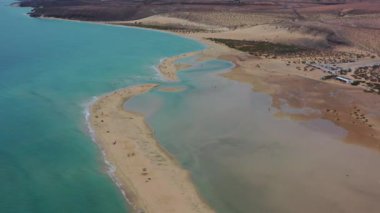 Fuerteventura, Kanarya Adaları 'ndaki Playa de la Barca' da yürüyen bir çiftin insansız hava aracı görüntüleri. Turkuaz okyanus, kıyı manzarası, seyahat ve romantik konsept