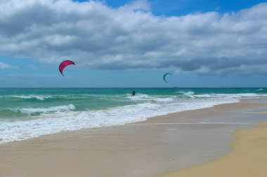 Uçurtmacı Sotavento Sahili 'nde dalgalarda sörf yapıyor. Güçlü rüzgar ve açık mavi gökyüzü, uçurtma ve rüzgar sporları için popüler bir yer..