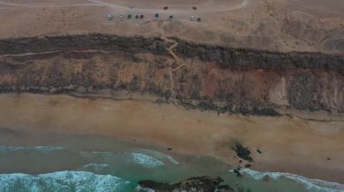 Fuerteventura 'daki engebeli Playa de la Escalera kıyılarının panoramik hava manzarası yumuşak ışık ve bulutlu hava koşullarıyla.