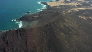 Lobos Adası Doğal Parkı 'ndaki La Caldera Dağı' nın açık ve güneşli bir günde manzarası. Volkanik manzara, kıyı manzarası ve Kanarya Adaları 'ndaki el değmemiş doğa..