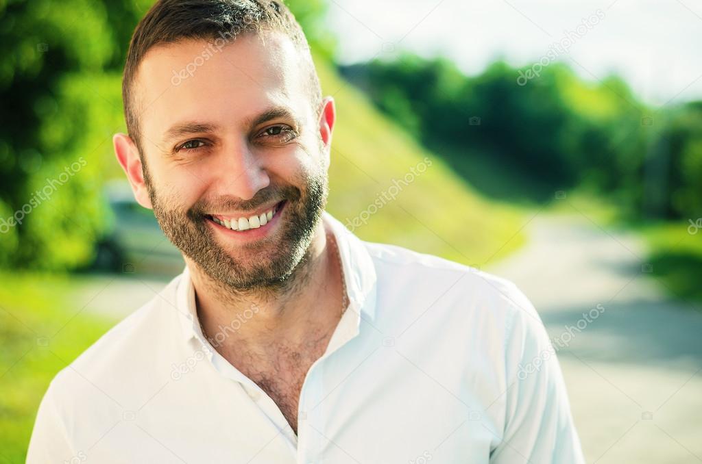 Close-up of a man smiling outside