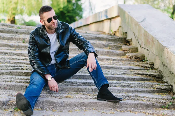 Young, fashioned man in black leather jacket, sunglasses and jea — Stock Photo, Image