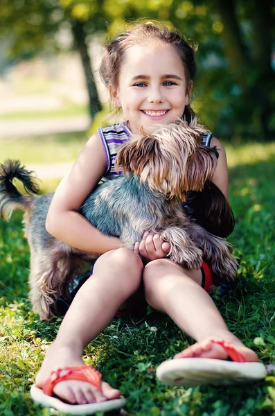 köpek çim ile oynarken mutlu küçük kız
