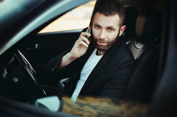 Arabasında bir cep telefonu kullanarak iş adamı