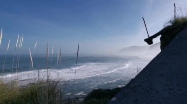 Güneşli bir sonbahar sabahında uçurumdan kayalara vuran dalgaların görüntüsü