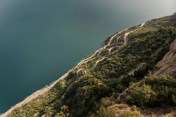 Mountain road along the sea. Serpentine. Aerial view of road going along the mountain and sea. Drone photography from above