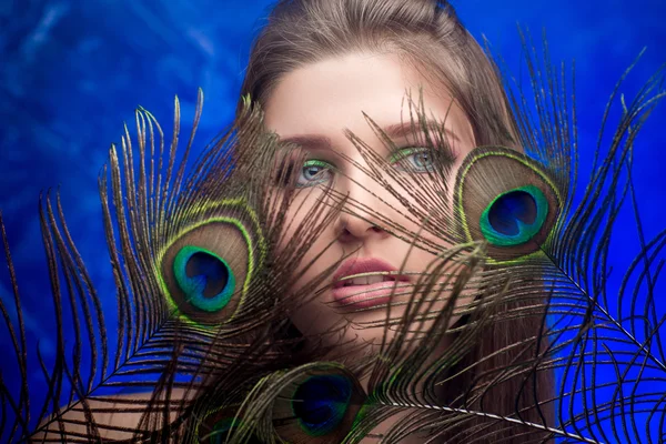 Chica con maquillaje brillante y pluma de pavo real — Foto de Stock