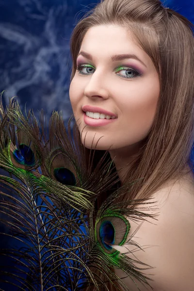 Parlak makyaj ve tavus kuşu feathe kızla — Stok fotoğraf