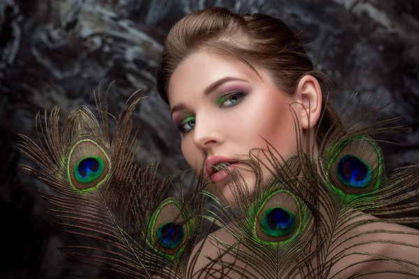 Girl with bright  makeup and peacock feathe — Stock Photo, Image