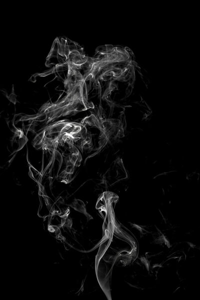 Curls of white smoke on a black background