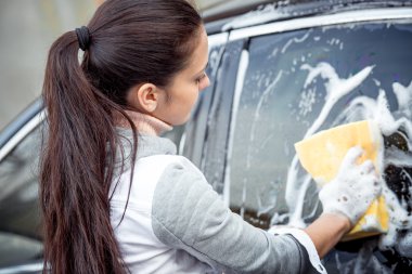 Kız arabayı yıkar.