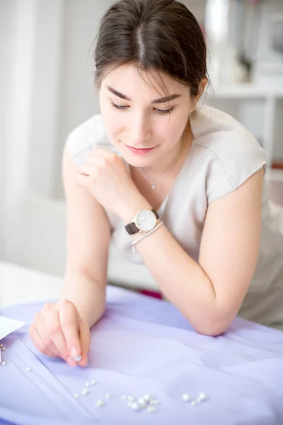 Skräddaren plockar upp pärlor — Stockfoto