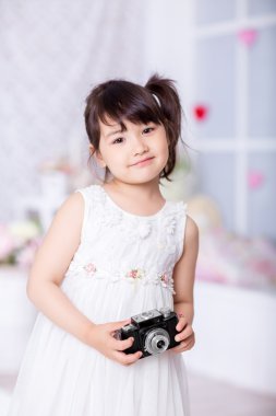 küçük kız eski bir kamera tutarak