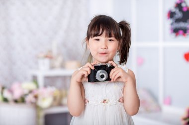 küçük kız eski bir kamera tutarak