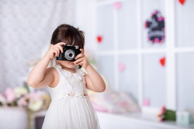 küçük kız eski bir kamera tutarak