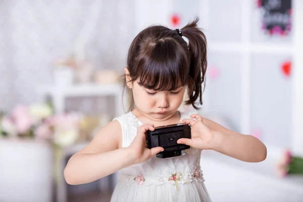 Menina segurando uma câmera velha — Fotografia de Stock