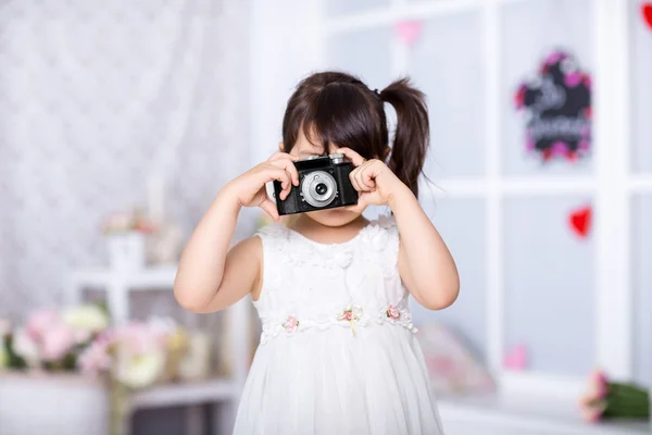 Menina segurando uma câmera velha — Fotografia de Stock