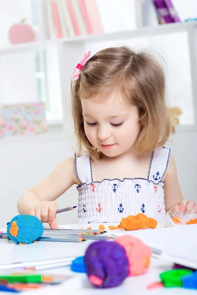 Girl playing with colored plasticine — Stock Photo, Image