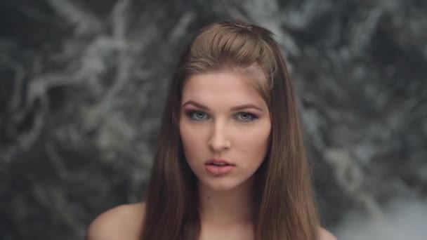 Meisje model rook blazen rook en gooit haar haar lip bijten — Stockvideo