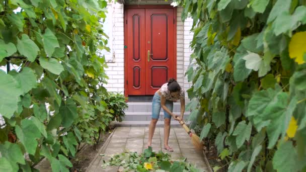 Жінка очищається у дворі . — стокове відео