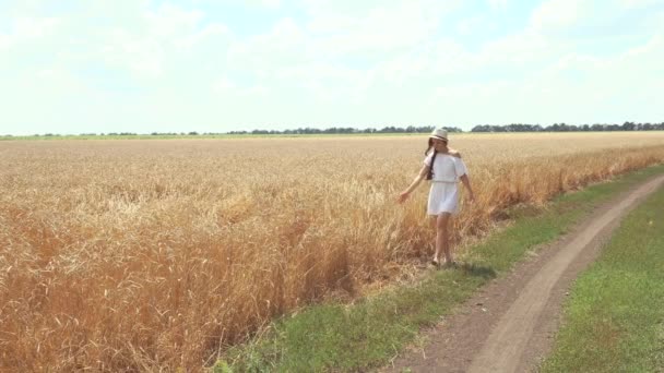 Vrouw in een witte jurk loopt over de weg — Stockvideo