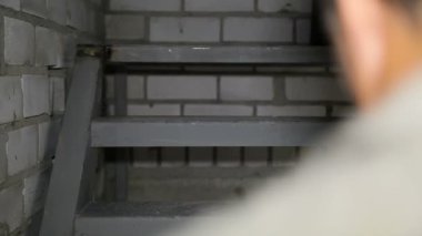 İnşaat işçisi merdiven kovası ile tırmanıyor