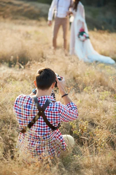 Düğün fotoğrafçısı gelin ve damadın fotoğraflarını çeker. — Stok fotoğraf