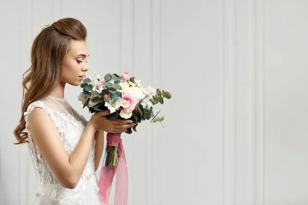 Schöne zarte junge Braut mit Blumenstrauß — Stockfoto